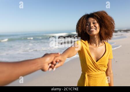 Mixed race woman smiling on the beach Stock Photo