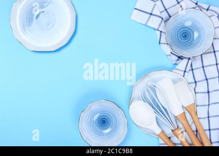 Varicolored ceramic plates and bowls on blue background Stock Photo