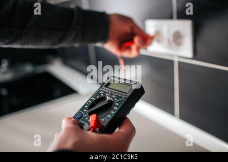 Electrician, Electrician installing new current socket with screwdriver. Installing electrical outlet or socket - closeup on electrician hands. Stock Photo