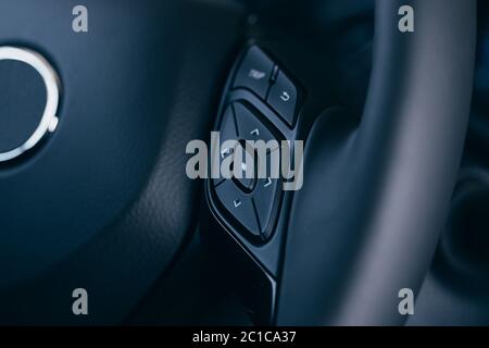 close up Modern black steering wheel with multifunction buttons Integrated stereo controls pushes the for quick control technology in the car. Stock Photo