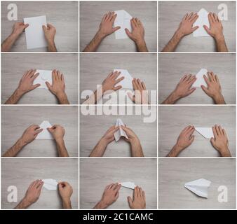 How to make origami paper airplane step by step photo instruction on wooden table with arms. Stock Photo