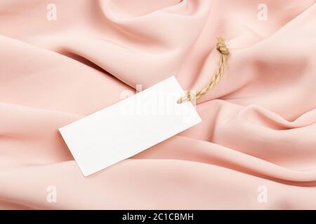 Rectangular Tag on a clothes. fashion, people and shopping concept - close up price tag of clothing item Stock Photo