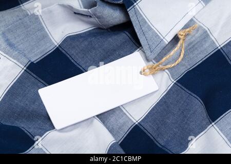 Rectangular Tag on a clothes. fashion, people and shopping concept - close up price tag of clothing item Stock Photo