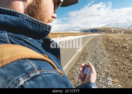 Close-up Hipster man using a compass on a snowy mountain Stock Photo