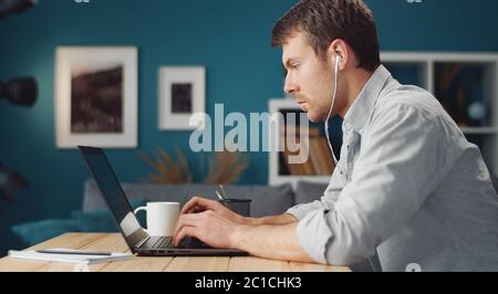 Serious man using laptop, side Stock Photo