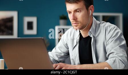 Focused man using laptop, home Stock Photo