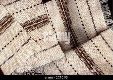 Linen kitchen napkins close-up. Light napkins made of natural fabric with a pattern and fringe. Restaurant business background. Selective focus. Stock Photo