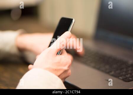 Office world, time brake. Businessman working at the wood table with new business project. Man touching screen modern mobile pho Stock Photo