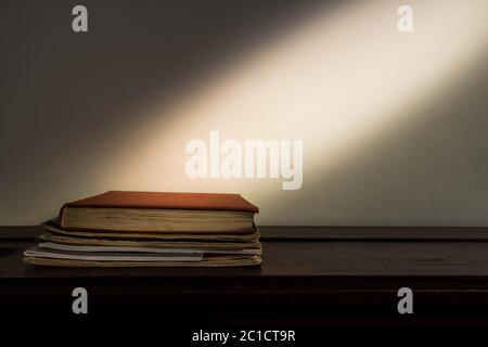 antique stack of books and notebooks with an expanding dust Stock Photo