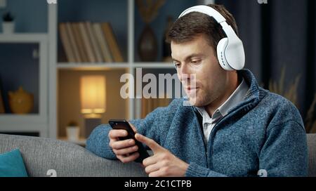 Man using gadgets sitting sofa Stock Photo