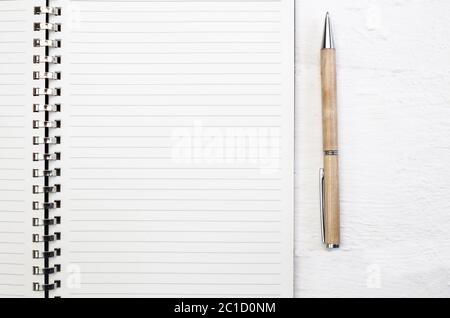 Blank note pad page close up on white deck table with pen Stock Photo