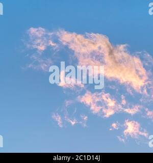Square frame Wispy white clouds tinged pink at sunset Stock Photo