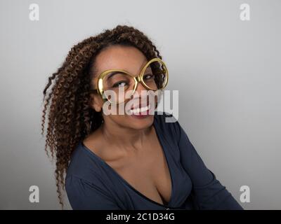 Horizontal portrait of a joyful Afro American woman wearing funny eyeglasses Stock Photo