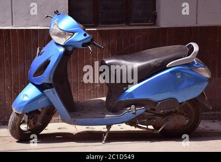 Blue color scooter or scooty parked at road side in India Stock Photo