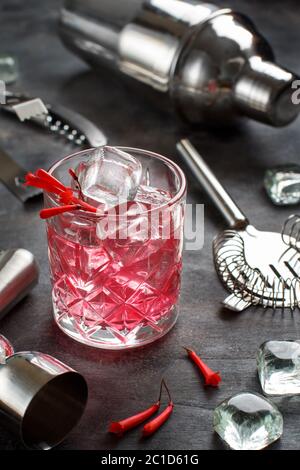 Cosmopolitan cocktail in a glass decorated with pink flowers close up on white table Stock Photo