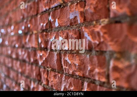 Loft red brick wall, angled view. Polished brick wall in attic interior. Background texture for design, copy space. Stock Photo