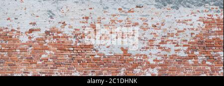 Panorama of a very crooked, old brick wall, partially with plaster Stock Photo