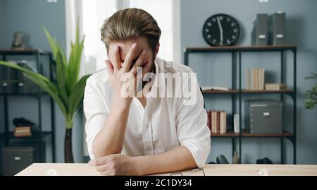 Exhausted businessman covering his face Stock Photo