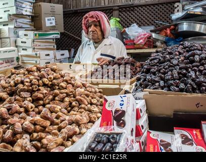 Iranian old man selling fresh and dry dates as a street vendor stall or shop in souk mubarakiya, Kuwait. Stock Photo