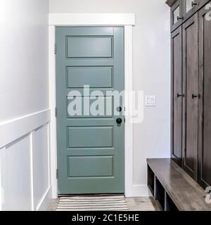 Square Hallway with runner rug on the floor that leads to the fire door of a home Stock Photo