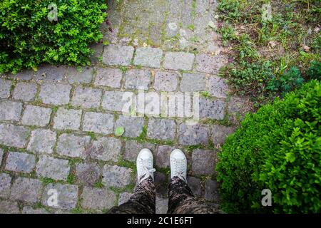 Close-up of sneaker shoes on a cobbled street Stock Photo