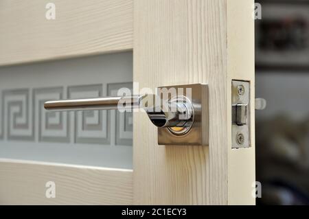 Modern style doorknob on a wooden door. Door lock Stock Photo