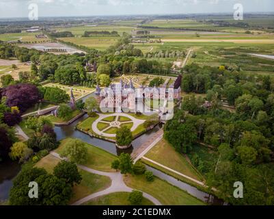 old historical garden at Castle de Haar Netherlands Utrecht on a bright summer day, young couple men and woman mid age walking in the castle garden Stock Photo