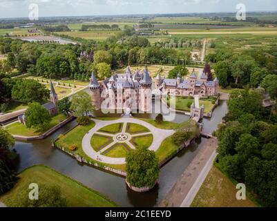 old historical garden at Castle de Haar Netherlands Utrecht on a bright summer day, young couple men and woman mid age walking in the castle garden Stock Photo