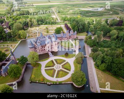 old historical garden at Castle de Haar Netherlands Utrecht on a bright summer day, young couple men and woman mid age walking in the castle garden Stock Photo