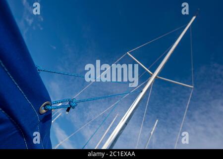 Yacht mast against a blue sky, close up of rigging. Stock Photo
