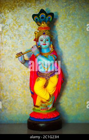 Colorful figure of the Hindu God Krishna playing the flute. Lord Krishna playing the flute. Stock Photo