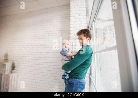 Happy loving family. Young father holds baby son in her arms. Stock Photo