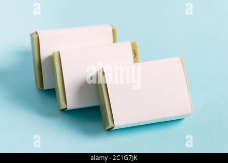 Three soap wrap box mock-up package with bar olive soap isolated on blue background Stock Photo