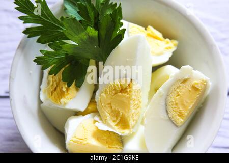 Boiled eggs, sliced isolated in the bowl. Halved eggs food in plate. Stock Photo
