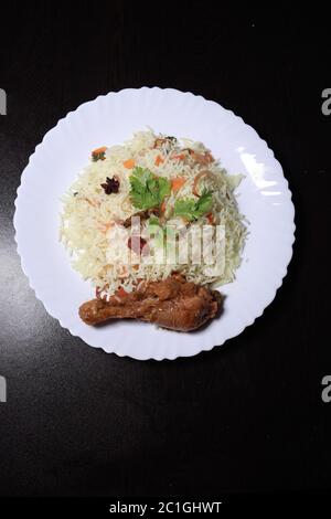 Chicken Biryani showing leg piece - It's a delicious recipe of Basmati rice mixed with with spicy marinated chicken in a bowl.  Served in a bowl or pl Stock Photo