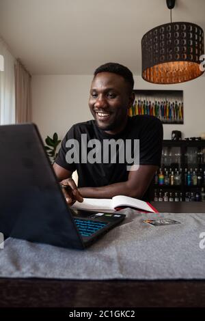 Young black man working from home smiling with toothy smile. Medium shot. Stock Photo