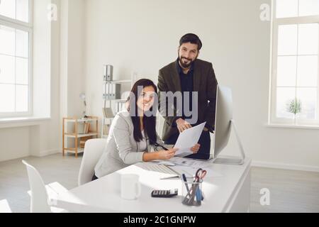 Business people smiling while standing in office. Stock Photo