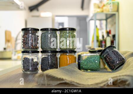 different spices and herbs in glass jars for cooking, indian spices, multi colored Stock Photo