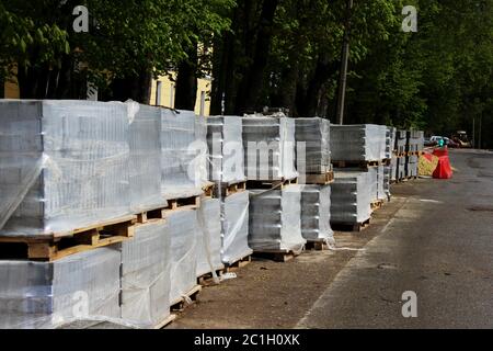 Grey paving slabs folded on a pallets during the reconstruction and repair of the square in the city Gatchina. Stock Photo