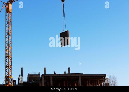 telescopic rack formwork monolithic slabs in the construction of a multistory building. The crane transports the slab to overlap Stock Photo