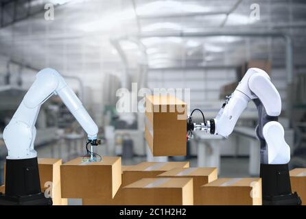 The Robotic arms carries cardboard box for delivery industry packing Stock Photo
