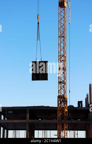 telescopic rack formwork monolithic slabs in the construction of a multistory building. The crane transports the slab to overlap Stock Photo