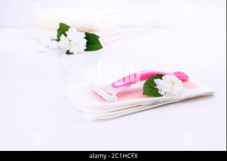 a set of different means for epilation on a colored background. Removal of unwanted hair. Body care products, towels, jasmine flowers, wax strips, razor. Minimalism, top view. flatlay Stock Photo