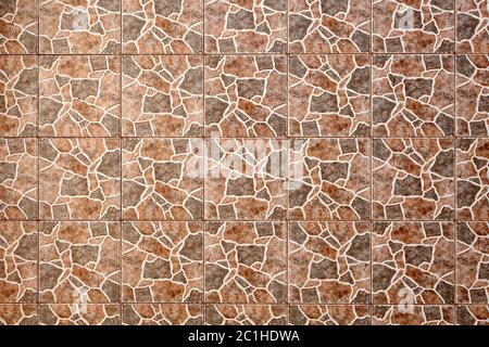 The texture of the wall is tiled with spotted ceramic tiles imitating the skin of a giraffe. Stock Photo