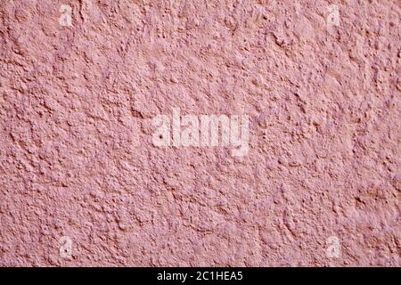 Rough, grainy surface of a plastered wall with pink stucco, abstract texture for background. Stock Photo