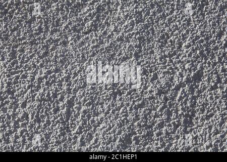 Texture of gray plastered wall with rough granular plaster. Stock Photo