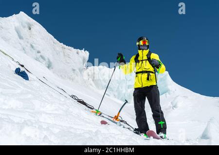 A freerider skier in complete outfit stands on a glacier in the North Caucasus Stock Photo