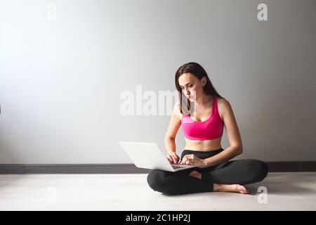 Sporty young brunette woman using laptop Stock Photo