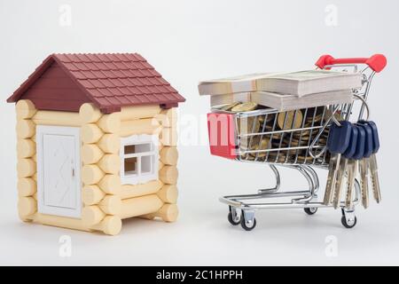 Toy house, trolley with money and a bunch of keys to the house Stock Photo