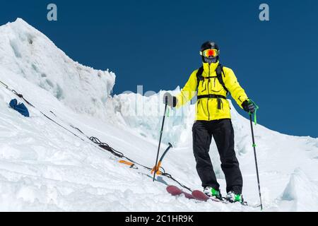 A freerider skier in complete outfit stands on a glacier in the North Caucasus Stock Photo